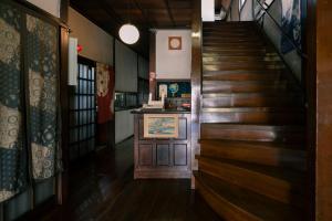 松本Nunoya Ryokan的楼梯通往铺有木地板的客房