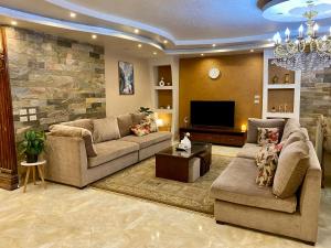 开罗Cozy 3BR Apartment in Maadi的客厅配有两张沙发和一台电视
