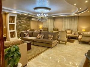 开罗Cozy 3BR Apartment in Maadi的客厅配有沙发、椅子和吊灯