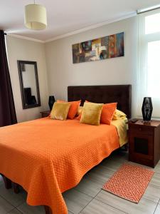 特木科Depto Ginebra 1 dorm con estacionamiento的一间卧室配有一张带橙色毯子的床