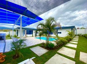 GiganteCompostela Cabañas Gigante的一座带游泳池和蓝伞的房子