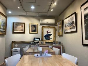 大阪指南针画廊公寓的餐厅配有桌椅和墙上的照片
