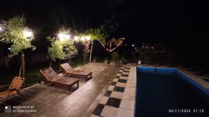 卢汉德库约aires de montaña的一个带两把椅子的庭院和一个晚上的游泳池
