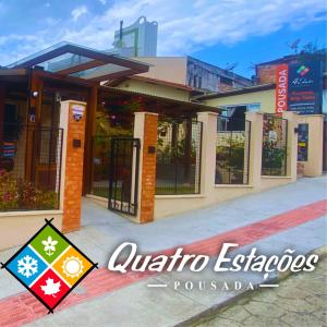 格拉瓦塔尔Pousada Quatro Estações的前面有标志的建筑