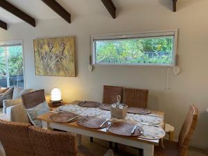阿希帕拉AHIPARA GOLDENSANDs的一间带桌椅和窗户的用餐室