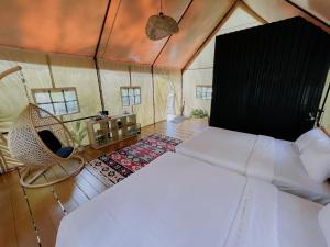 TangkubanperahuLuxury Deck Cabin的一间卧室,卧室内配有一张床和一把椅子