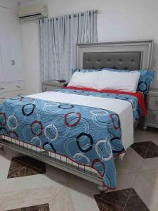 MatancitaEspaciosa casa en Matancitas a 3 min de la Playa的一间卧室配有一张带蓝色和红色毯子的床