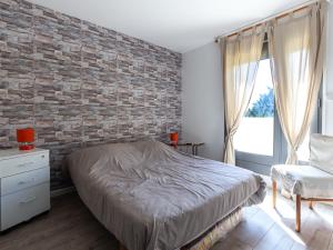 塞尼奥斯Appartement Seignosse, 3 pièces, 4 personnes - FR-1-239-463的卧室设有砖墙、一张床和一把椅子