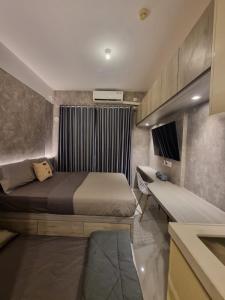 TjilandakMashley Room Prestige Apartment SKY HOUSE BSD的一间卧室配有一张床和长凳