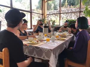 库斯科Spirit Of The River Lodge的一群坐在桌子旁吃食物的人
