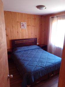 利马切Cabañas Marlen的一间卧室配有一张带蓝色棉被的床