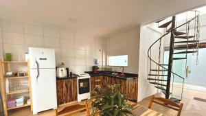 盖比姆Viva Guaibim: Casa de Praia com Piscina e Churrasqueira的一间带白色冰箱和螺旋楼梯的厨房