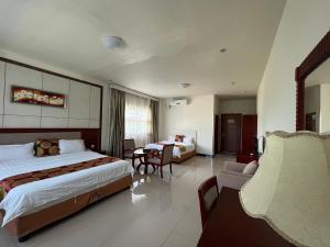 努库阿洛法Meida Hotel的酒店客房带一张床、一张桌子和椅子