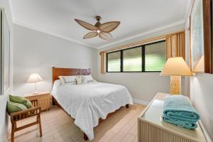 科洛阿Poipu Shores 403A的一间卧室配有一张床和吊扇
