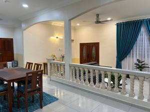 MerlimauMutiara Villa Homestay - Comfort Away From Home的用餐室和带桌子的客厅