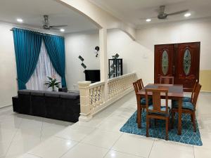 MerlimauMutiara Villa Homestay - Comfort Away From Home的客厅配有桌子和沙发