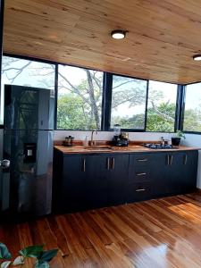 约帕尔Tree House Glamping的厨房配有黑色橱柜和木制天花板