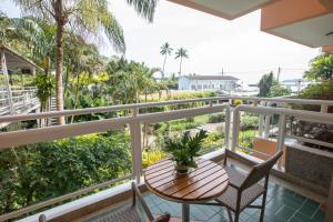 攀瓦海滩Kantary Bay Hotel Phuket的阳台配有桌椅和棕榈树。