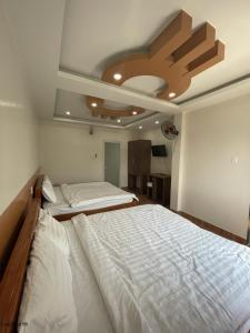 áº¤p VÄ©nh ÃÃ´ngKhách sạn Trung Hiếu的一间卧室设有两张床和天花板