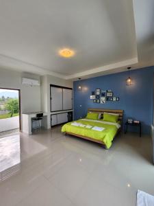 三百岭Cordelia Resort Sam Roi Yot的一间卧室设有绿色的床和蓝色的墙壁