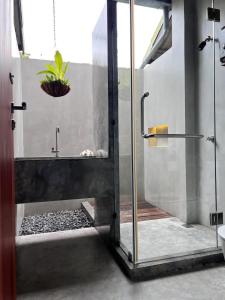 通萨拉Ngam Hidden Cabin Room的一间带淋浴的浴室,里面装有植物