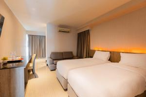 曼谷Sukhothai Hotel and Residence的酒店客房,设有两张床和一张沙发