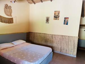 BubaqueMANGO LODGE的一间小卧室,配有一张床,墙上挂着图片