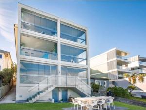 悉尼Tamarama Beachfront Apartment on Bondi to Bronte Walk的一座大型建筑,前面设有楼梯