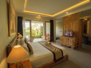 德格拉朗The Nenggala Suite的一间卧室配有一张大床和电视
