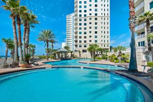 彭萨科拉Beach Front Luxury, Amazing Views,150 - 5 Stars, 19th Floor- Indigo Condo的一座棕榈树和建筑的大型游泳池