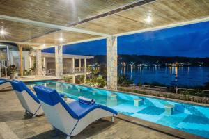 蓝梦岛Nusa View的一个带椅子的游泳池,享有水景