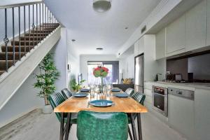 悉尼Superb 3 Bedroom Apartment Surry Hills的厨房配有带绿色椅子的木桌