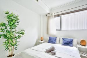 悉尼Superb 3 Bedroom Apartment Surry Hills的一间卧室配有一张带蓝色枕头和植物的床