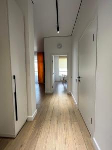 阿斯塔纳Raisson Ahotel Grand Turan 32的空的走廊,有白色的墙壁和木地板