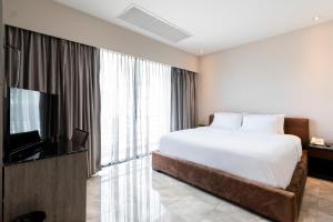 曼谷Sukhothai Hotel and Residence的一间卧室配有一张床和一台平面电视