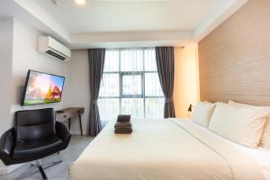 清迈依思迪酒店-SHA Extra Plus的酒店客房配有一张床、一把椅子和一台电视。