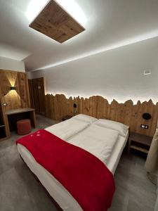卡里索洛阿尔伯格加尔尼玛蒂娜酒店的一间卧室设有一张带木墙的大床