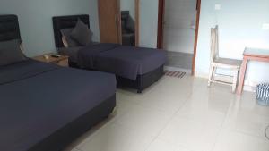 库塔努卡海滩旅舍 的一间卧室配有两张床、一张沙发和一张桌子