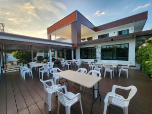 三百岭Cordelia Resort Sam Roi Yot的一间在甲板上配有白色桌椅的餐厅