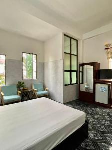 芹苴Khách sạn Nam Đô 2的一间卧室配有一张大床和两把椅子