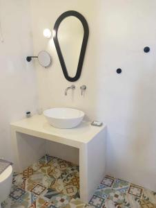乔拉弗雷恩多斯Anemousa Hotel的浴室设有水槽和墙上的镜子