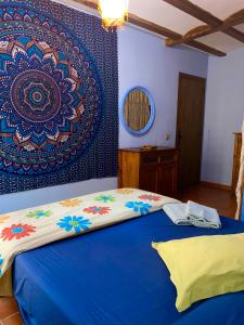 赫里卡Cuatro Rosas Jerica的一间卧室配有一张床,墙上挂着绘画作品