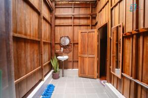 Ấp Nhơn BìnhMuong Dinh Lodge的走廊上设有带木墙和水槽的浴室
