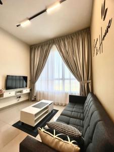 马六甲Melaka AmberCove Homely Seaview 2R2B的客厅配有黑色沙发和电视