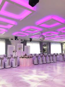 BralinMotel Za Miedzą的配有桌椅和紫色照明的客房