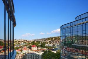 第比利斯Paragraph Freedom Square, a Luxury Collection Hotel, Tbilisi的从玻璃建筑中欣赏到城市美景
