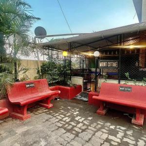 罗纳瓦拉MOUNT BUNGALOWS-1 BEDROOM Private pool chalet -wifi -private pool-ac的咖啡馆前的一组红色长椅