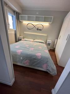 韦尔米廖Luna Bianca Apartment的一间卧室,上方有一张带爱情标志的床