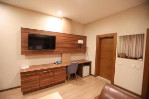 巴库Park Suite Hotel的一间设有一张桌子的房间,墙上有一台电视机