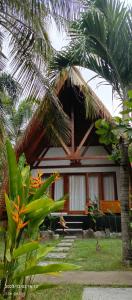 龙目岛库塔Mengalung Bungalow的前面有棕榈树的房子